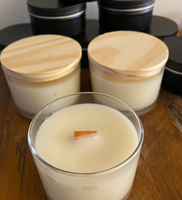 Velas aromáticas em copos de vidro transparente com tampa de madeira e pavio de madeira
