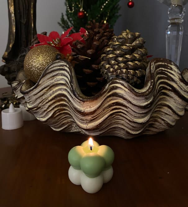 Mini vela bubble verde e branca acesa sobre uma mesa